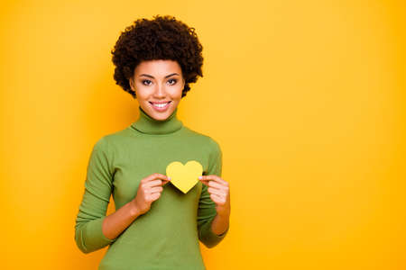 Photo of wavy cheerful cute nice pretty woman standing near empty space holding yellow heart of love...
