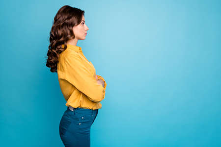 Profile photo of amazing curly business lady hold hands crossed seriously looking colleagues dislike coming work late wear yellow shirt trousers isolated blue color backgroundの写真素材
