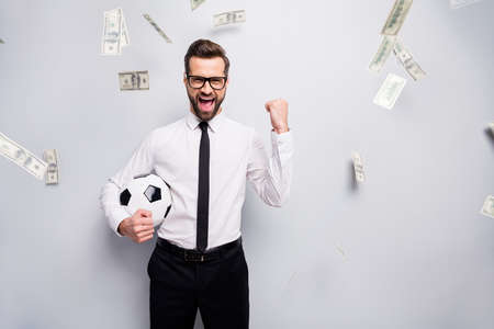Ecstatic funky investor banker man winner football fan hold ball raise fists support team players...