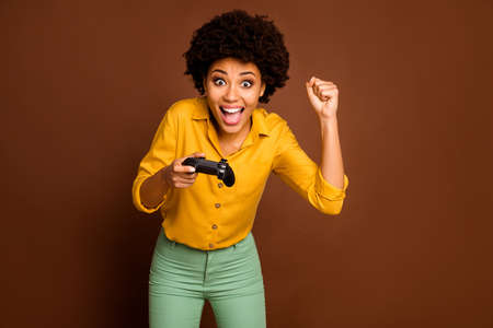 Photo of crazy funny dark skin curly lady hold joystick plying video game addicted gamer online team...