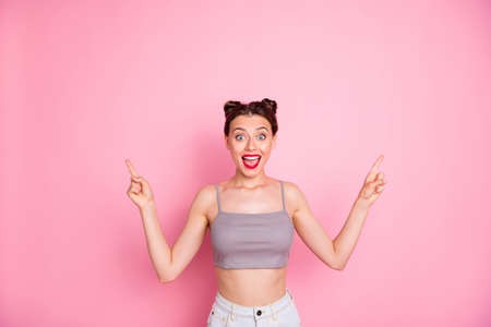 Photo of attractive lady cute buns red lips slim shapes indicate both arms empty space show low...