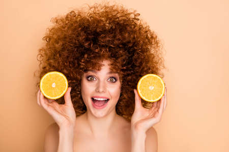 Close-up portrait of her she nice cute charming lovely attractive cheerful cheery wavy-haired teen girl holding in hands showing lemon useful nutrition isolated over beige pastel backgroundの写真素材