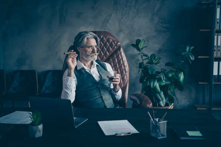 Portrait of his he nice attractive chic classy serious focused gray-haired man drinking liquor...