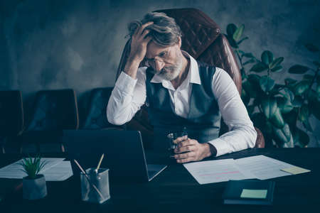 Portrait of his he nice attractive chic classy tired exhausted overwhelmed, overworked gray-haired man drinking liquor at modern loft industrial style interior work place station indoorsの写真素材