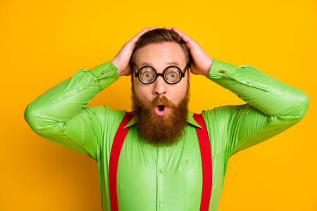 Close up photo funky astonished geek nerd man funky spectacles look unbelievable unexpected high school novelty touch hands head wear good look outfit isolated vivid color backgroundの写真素材