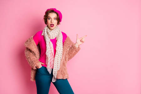 Portrait astonished girl point finger promotion adverts scream wow recommend choice decision advice wear french blue trousers outerwear jumper dotted shawl isolated pink color backgroundの写真素材