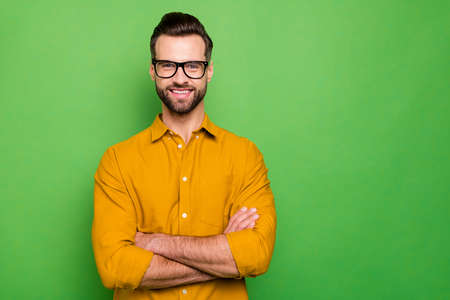 Close-up portrait of his he nice attractive cheerful cheery bearded guy in casual formal shirt office employee folded arms isolated on bright vivid shine vibrant green color backgroundの写真素材