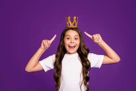 Portrait of her she nice attractive lovely charming cheerful cheery wavy-haired girl demonstrating diadem isolated on bright vivid shine vibrant purple violet lilac color backgroundの写真素材