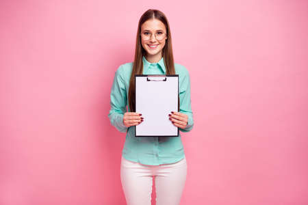 Portrait of confident smart professional marketer girl show clipboard with white empty paper for signature wear good look turquoise outfit isolated over pastel color backgroundの写真素材