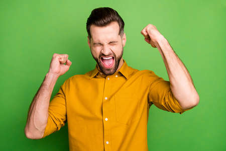 Close-up portrait of his he nice attractive cheerful cheery ecstatic guy in formal shirt celebrating great luck triumph isolated on bright vivid shine vibrant green color backgroundの写真素材