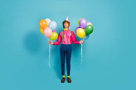 Full length photo of funky funny gentleman guy prepare anniversary party blow noisemaker hold many...