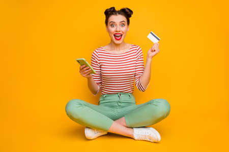 Full body photo of pretty lady sit floor legs crossed hold telephone credit card use online payment...