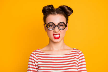 Closeup photo of pretty crazy lady student grimacing grinning showing teeth wear round circle geek specs striped red white shirt isolated bright yellow color backgroundの写真素材