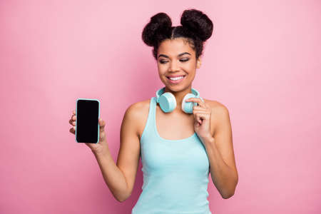 Close-up portrait of her she nice attractive lovely pretty charming cheerful cheery wavy-haired girl showing new novelty digital device isolated over pink pastel color backgroundの写真素材