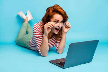 Full length close up photo impressed crazy woman lie floor use computer read incredible blogging...