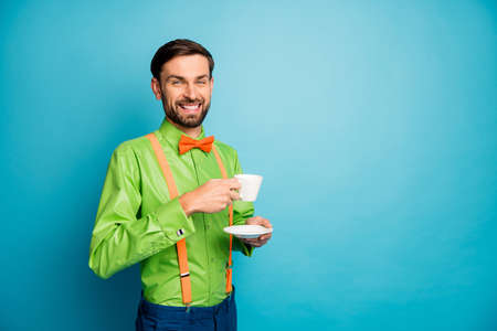 Portrait of his he nice attractive confident cheerful cheery guy wearing festal shirt drinking latte rest relax isolated on bright vivid shine vibrant blue green teal color backgroundの写真素材