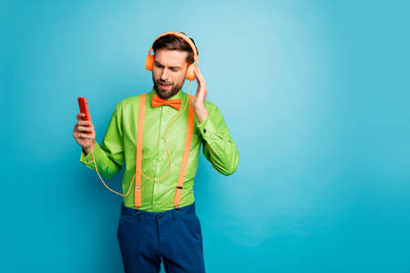 Portrait of his he nice attractive addicted focused cheerful cheery guy listening hip hop music soul jazz funk isolated on bright vivid shine vibrant blue green teal turquoise color backgroundの写真素材