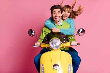Photo of funny lady guy couple in love sit drive rent vintage yellow moped visit foreign countries enjoy vacation together wear casual outfit isolated pink color backgroundの写真素材
