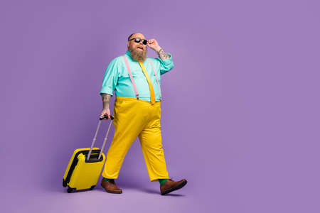 Full length body size view of cheerful confident guy carrying bag touching specs low cost airline...