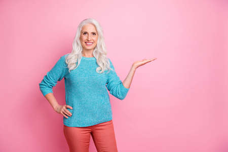 Portrait of positive cheerful old woman hold hand decide advise choose ads promotion wear good look...