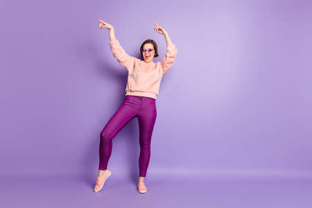Full size photo of excited girl dance feel rejoice crazy enjoy nightlife club wear pastel pullover good look outfit isolated over violet color backgroundの写真素材