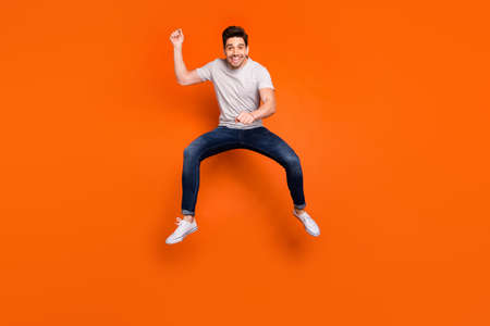 Full length photo of funky guy jump high up pretending horse riding rushing speed fast excited mood...