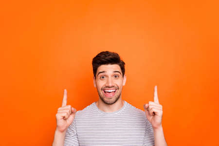 Closeup photo of attractive funny guy hold hands fingers direct up empty space excited good mood...