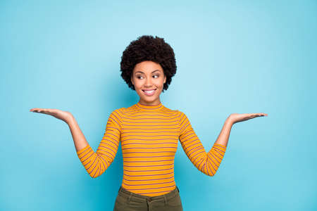 Photo of beautiful dark skin wavy lady hold open palms presenting novelty products advising two...