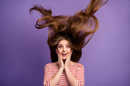 Portrait of astonished energetic girl have her hairstyle fly touch hands face impressed by new...