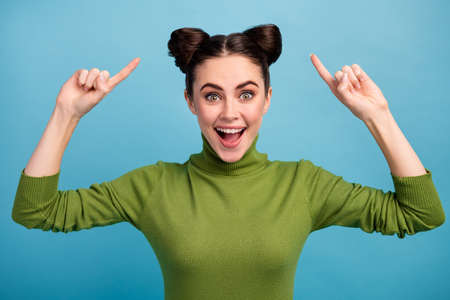 Photo of attractive amazed funny teen lady good mood indicating fingers hairdo advising cool hair stylist wear warm green turtleneck pullover isolated blue color backgroundの写真素材