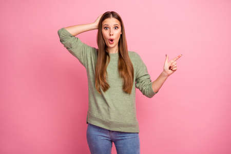 Portrait of astonished funny girl point index finger copyspace impressed by incredible ads promo touch hands head scream wow omg wear good look pullover isolated pastel color backgroundの写真素材