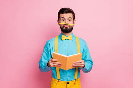 Portrait of his he nice attractive comic humorous cheerful bearded guy wearing mint shirt grimacing holding in hands diary pout lips isolated on pastel pink color backgroundの写真素材