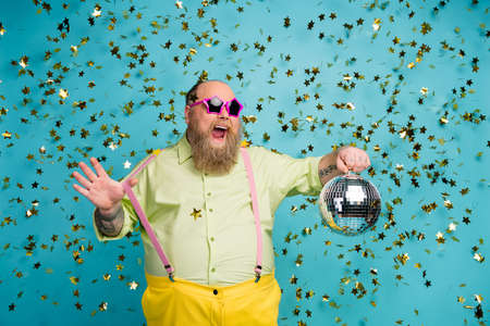 Portrait of his he nice attractive cheerful cheery glad bearded mature guy holding in hand disco...