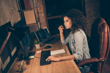 Top above high angle view profile side photo thoughtful afro american girl web geek hacker sit evening desk look pc screen work framework database script test server in workplace workstationの写真素材