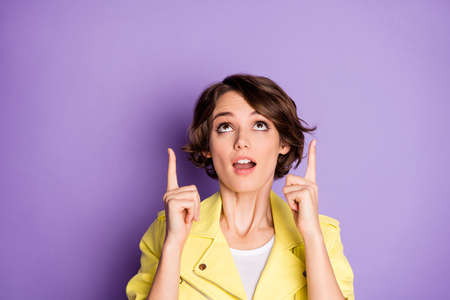Close up photo astonished funky girl point index finger up empty space demonstrate incredible ads promotion impressed scream wow omg wear trend clothes isolated violet color backgroundの写真素材