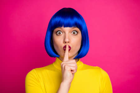 Shh. Closeup photo of attractive funny lady modern look hold finger on lips big eyes wear stylish yellow turtleneck blue short blue wig isolated vibrant pink color backgroundの写真素材