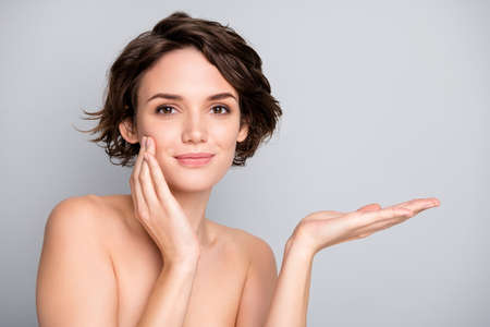 Portrait of positive dreamy harmony girl hold hand touch finger cheeks recommend new anti aging rejuvenation cream to make skin soft silky fresh isolated over grey color backgroundの写真素材