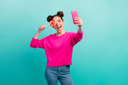 Portrait of attractive cheerful cheery wavy-haired girl making selfie closing eye with lollipop...