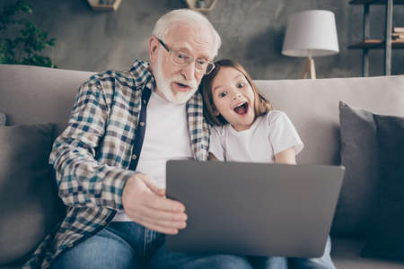 Photo of crazy old aged grandpa pretty small granddaughter sit sofa stay house quarantine watch...