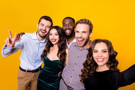 Photo of attractive two fancy ladies three macho guys company students graduation party best friends buddies making selfies showing v-sign symbol isolated yellow color backgroundの写真素材