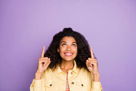 Portrait of positive cheerful afro american girl promoter point index finger copyspace recommend...