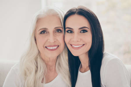 Close-up portrait of two nice attractive lovely tender cheerful women mom mommy adult daughter...
