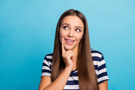 Closeup photo of pretty beautiful lady good mood flirty interested look up empty space clever creative person wear white striped sailor t-shirt isolated blue backgroundの写真素材
