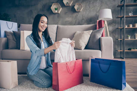 Full body photo of nice charming girl sit on carpet have her shopping mall center packages deliver...