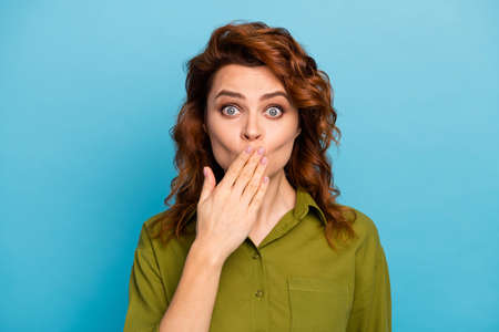 Portrait of astonished woman hide palm lips feel impressed about sharing her friend secret wear modern outfit isolated over blue color backgroundの写真素材