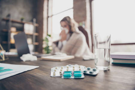 Close-up view of many different pills wavy-haired girl ceo boss chief director blowing nose grippe...