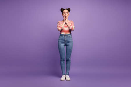 Full length photo of pretty teen lady two cute buns good mood arms on cheeks listen good news wear white red casual striped shirt jeans shoes isolated purple pastel color backgroundの写真素材