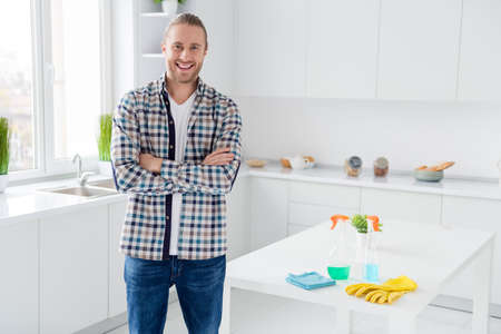 Portrait of his he nice attractive cheerful cheery content guy husband cleaning service worker perfect housework finish done folded arms in modern light white interior style kitchenの写真素材