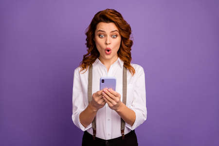 Photo of pretty crazy open mouth lady addicted casino player gamer hold telephone set online bets poker wait results wear white shirt suspenders pants isolated purple color backgroundの写真素材