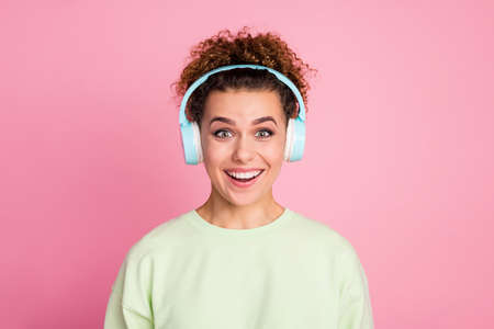 Portrait of astonished positive cheerful teenager girl listen wireless headset find favorite singer...